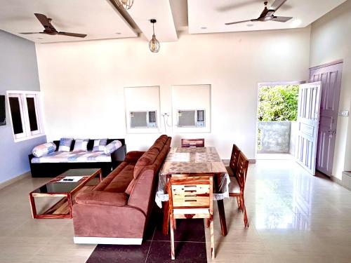 uma sala de estar com um sofá e uma mesa em Gooseberry Garden em Ayodhya