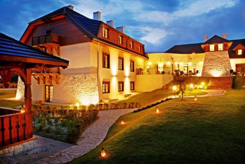 ein großes Haus mit Licht auf dem Rasen in der Unterkunft Hotel Kazimierzówka in Kazimierz Dolny