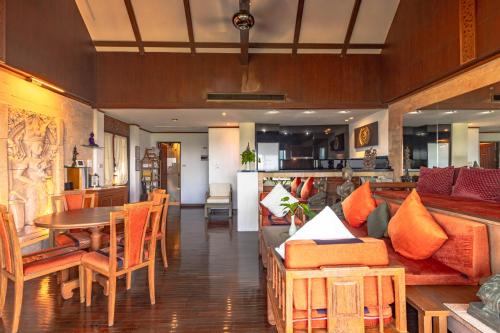 a living room with a couch and a table and chairs at Kamala Beach Estate Resort - SHA Extra Plus in Kamala Beach