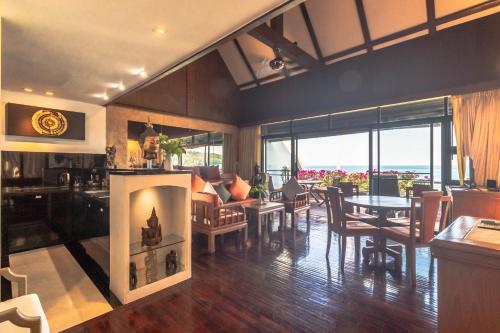 a living room with a fireplace and a dining room at Kamala Beach Estate Resort - SHA Extra Plus in Kamala Beach