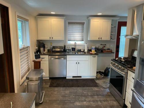 Una cocina con gabinetes blancos y un horno de estufa. en Creekside cottage, en Owatonna