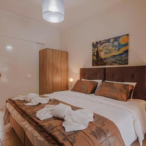 a bedroom with a large bed with towels on it at BELLA De LUX APTS in Ýpsos