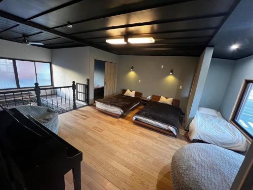 a room with two beds and a balcony at 貸し切りゲストハウスsai2nd in Yasugi