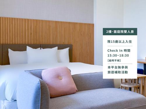 花蓮市的住宿－沐九行館，一间卧室配有一张带粉红色枕头的椅子的床