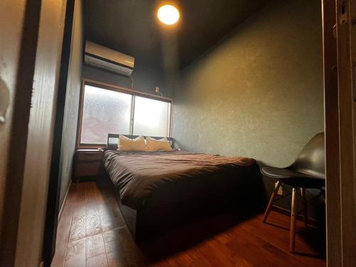 a small bedroom with a bed and a window at 貸し切りゲストハウスsai2nd in Yasugi