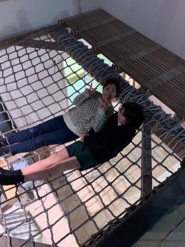 two people laying on top of a bed at 貸し切りゲストハウスsai2nd in Yasugi