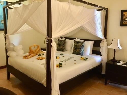 een slaapkamer met een hemelbed met speelgoed erop bij Cham Villas Resort in Mũi Né