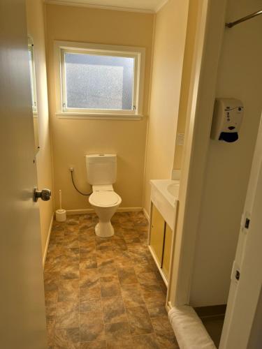baño con aseo y lavabo y ventana en Classic Motel, en Hamilton