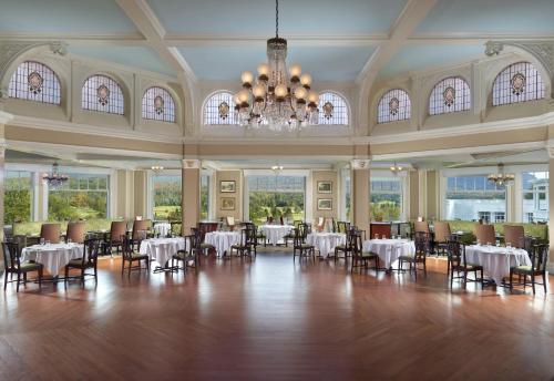 a dining room with tables and chairs and a chandelier at Omni Mount Washington Resort in Bretton Woods
