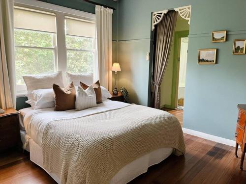 a bedroom with a large bed with a window at Woolrich Historic Garden Cottage in Olinda