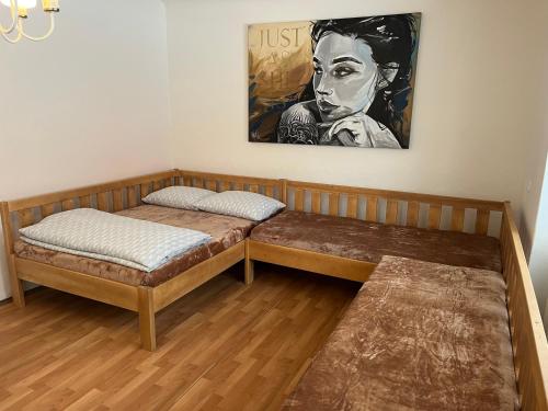 a room with two beds and a painting on the wall at Mikulovská chalupa in Mikulov