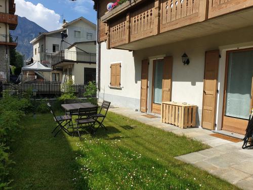 a patio with a table and chairs in a yard at Appartamento 'Reit' - Bormio - giardino, parcheggio, Wi-fi in Bormio