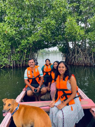 a group of people and a dog on a boat at Riverrootsstays in Munroe Island