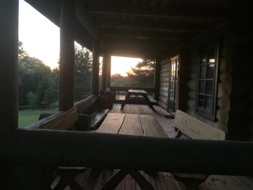 a porch of a cabin with a picnic table at Poilsis ant Virintų ežero kranto in Molėtai