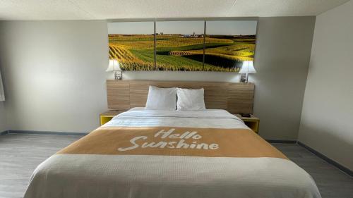 a hotel room with a bed with a sign on it at Days Inn by Wyndham Salina South in Salina