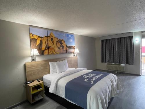pokój hotelowy z łóżkiem i obrazem na ścianie w obiekcie Days Inn by Wyndham Salina South w mieście Salina