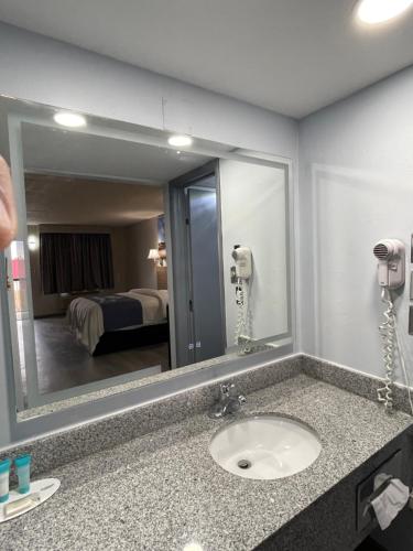 a bathroom with a sink and a large mirror at Days Inn by Wyndham Salina South in Salina
