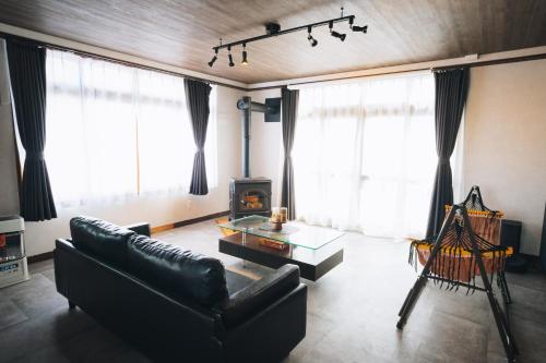 a living room with a couch and a table at かものや洞爺ファーマーズハウス Kamonoya Toya Farmer's House in Tōya