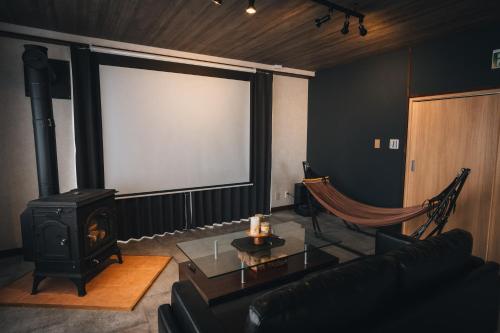 a living room with a couch and a screen at かものや洞爺ファーマーズハウス Kamonoya Toya Farmer's House in Tōya