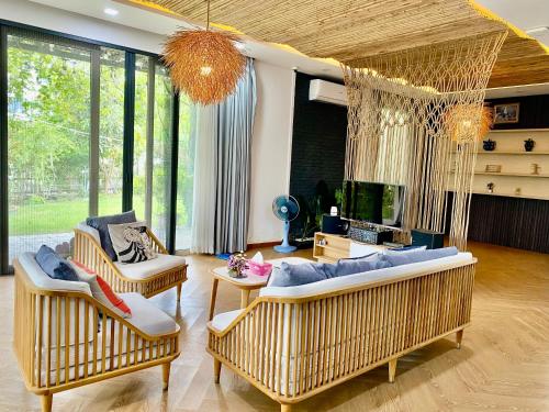 a living room with two couches and a hanging couch at Green villa in Bien Hoa