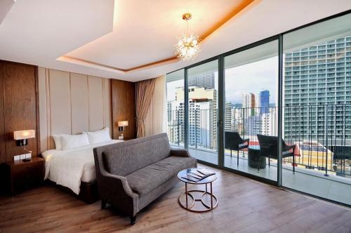 a hotel room with a bed and a couch at Panorama Nha Trang Condotel by One in Nha Trang