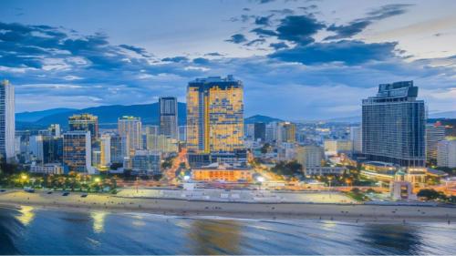 a skyline of a city with a beach at night at Panorama Nha Trang Condotel by One in Nha Trang
