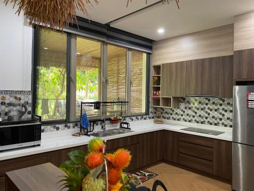 a kitchen with wooden cabinets and a large window at Green villa in Bien Hoa
