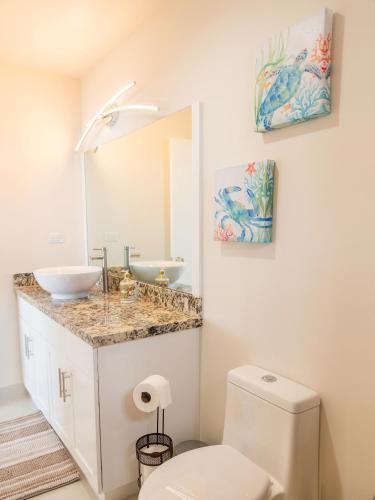 Un baño con inodoro, lavabo y espejo. en Calafia Condos, en Divisadero