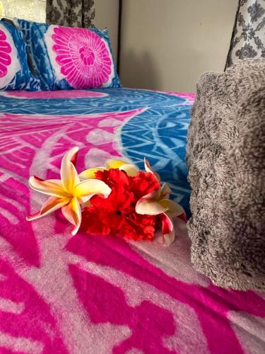 a bouquet of flowers sitting on top of a bed at Rangiriri Vacay Unit 1 in Amuri
