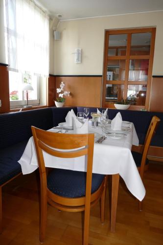 a dining room with a white table and chairs at Hotel Restaurant Schwane in Meßstetten