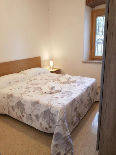 Un dormitorio con una cama grande con una manta. en Villa Montegolo, en Costermano