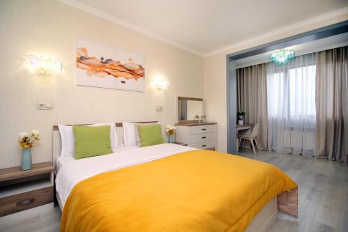ein Schlafzimmer mit einem großen Bett mit einer gelben Decke in der Unterkunft Жк Арбат двух комнатная in Almaty