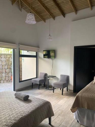 a bedroom with two beds and a table and chairs at Casa de ensueño, jacuzzi-fogata in La Cuadrilla