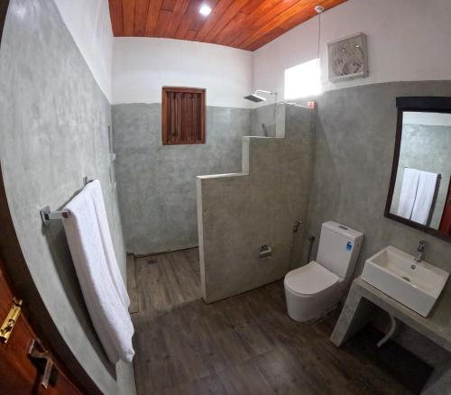 een badkamer met een wastafel, een toilet en een trap bij SurfBayVilla in Dikwella