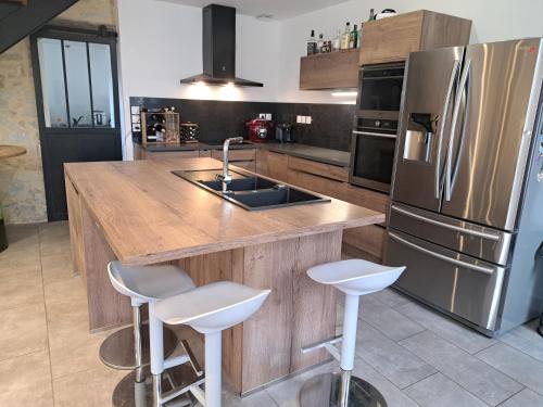 La cuisine est équipée d'un comptoir en bois et d'un réfrigérateur en acier inoxydable. dans l'établissement maison de vacance à mosles, à Mosles