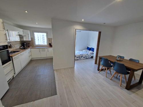 une cuisine et une salle à manger avec une table et une chambre avec un lit dans l'établissement Appartement comfortable à 200 m à pied du RER A, à Champs-sur-Marne