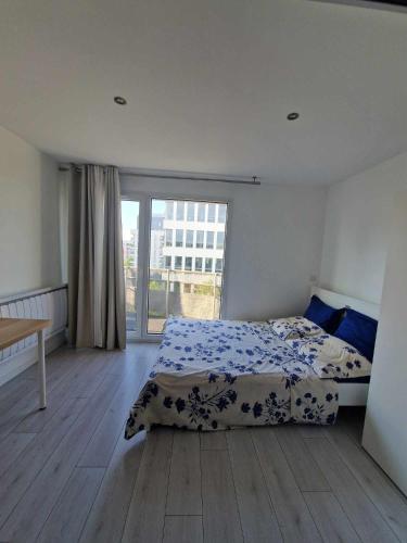 une chambre avec un lit et une grande fenêtre dans l'établissement Appartement comfortable à 200 m à pied du RER A, à Champs-sur-Marne