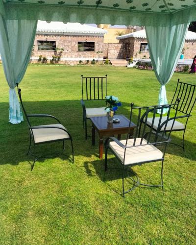 a group of chairs and a table in the grass at Ananda Resort in Pushkar