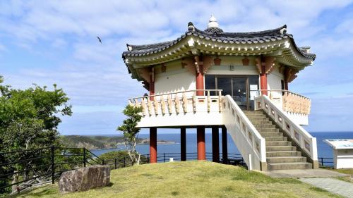 a small building on top of a hill with the ocean at Toyoko Inn Tsushima Hitakatsu in Tsushima