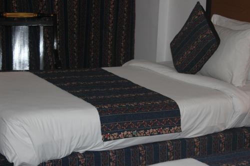 a hotel room with a bed with a pillow at Mehran Hotel Karachi in Karachi