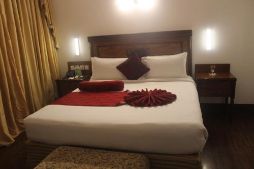 a bedroom with a large bed with white sheets and pillows at Mehran Hotel Karachi in Karachi