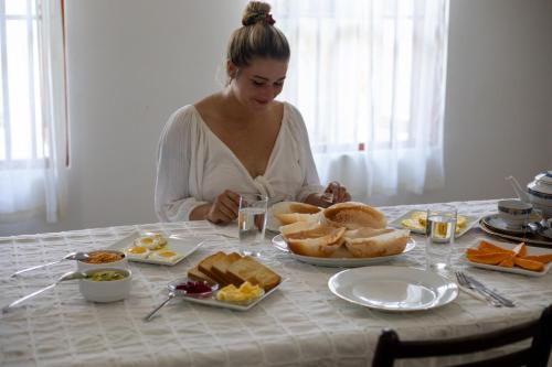 a woman sitting at a table with food on it at SurfBayVilla in Dickwella