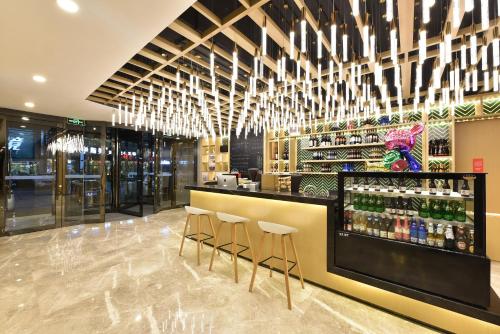 a bar in a restaurant with bar stools at Atour Light Hotel Shenyang Tiexi Plaza Wanxianghui in Shenyang