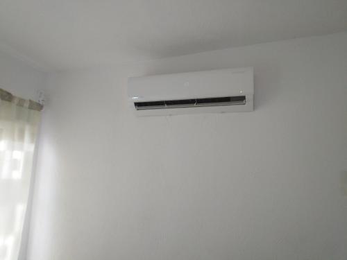 a air conditioner on a white wall in a room at casa tranquila in Naranjo