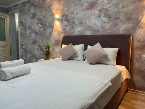 a bedroom with a bed with white sheets and pillows at 1-комн квартира в центре города in Qyzylorda