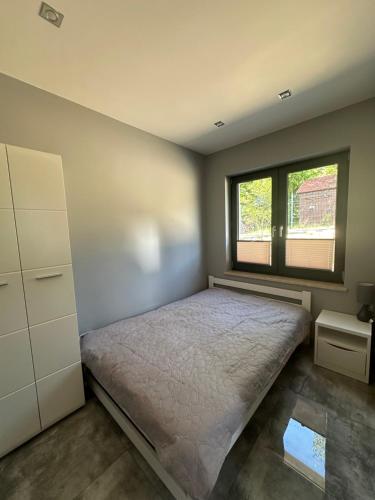 a bedroom with a bed and a window at Nova 26 in Klucze