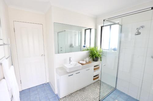 a white bathroom with a sink and a shower at Harbour Haven*Sea View*WIFI*Wine*Walk to the Beach in Robe