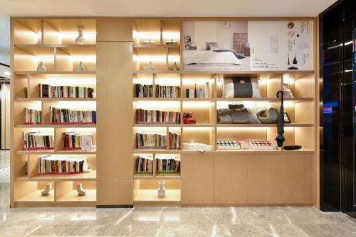 a library with a wall of books at Atour Light Hotel Shenyang Tiexi Plaza Wanxianghui in Shenyang