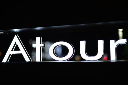 a sign for a store in a dark room at Atour Light Hotel Shenyang Tiexi Plaza Wanxianghui in Shenyang