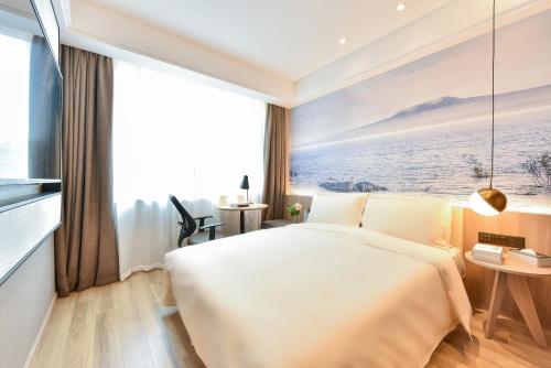 a hotel room with a large bed and a large window at Atour Light Hotel Shenyang Tiexi Plaza Wanxianghui in Shenyang
